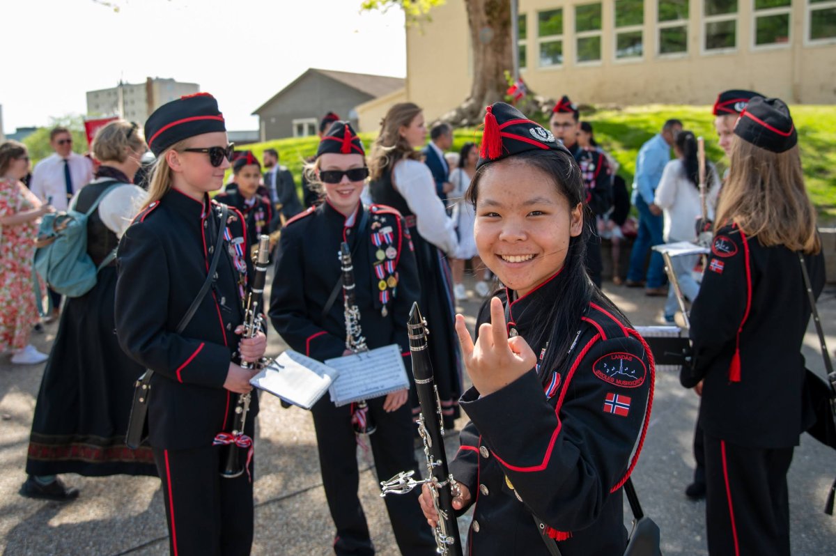 Nærare bilete av tre flotte ungdommar, klarinettistar i svarte og raude uniformer.