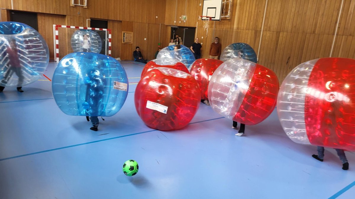 Boblefotball! Mange barn inni store blå og raude bobler.